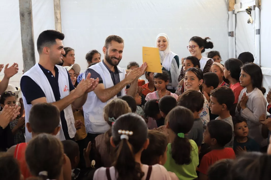 Zaměstnanci MSF obklopeni dětmi, Palestína, 2024. Foto: Mariam Abu Dagga / Lékaři bez hranic